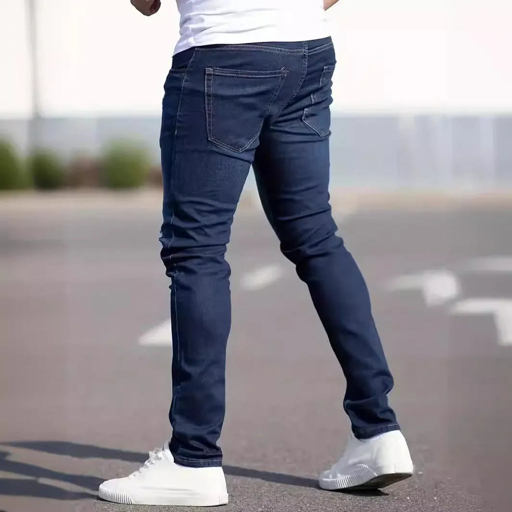 Man wearing dark blue slim-fit skinny jeans with a medium-elastic waist and zipper fly.