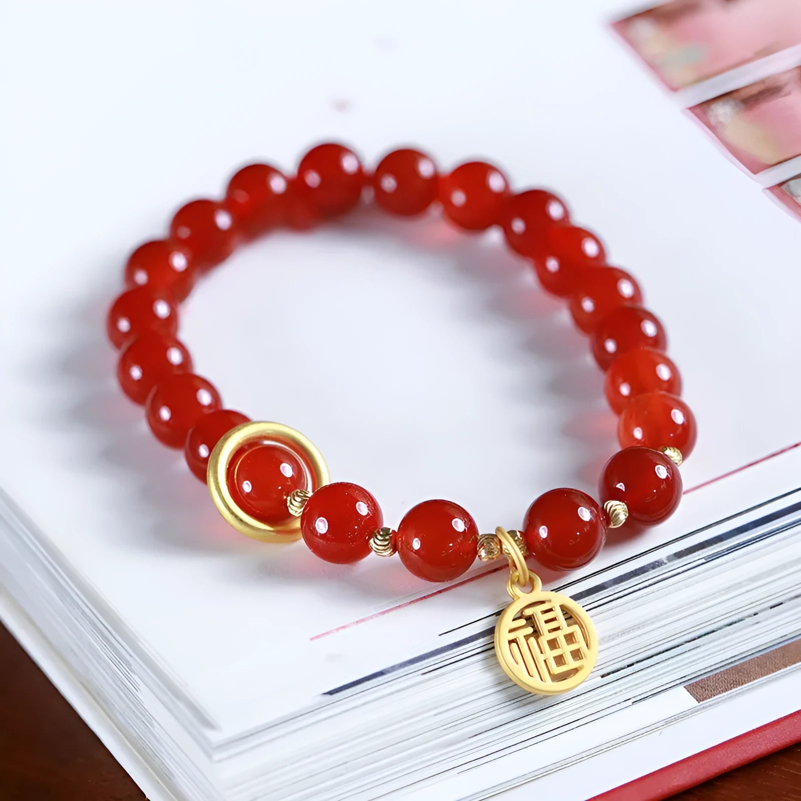 Close-up of a red agate beaded bracelet with woven design and a paper blessing card.