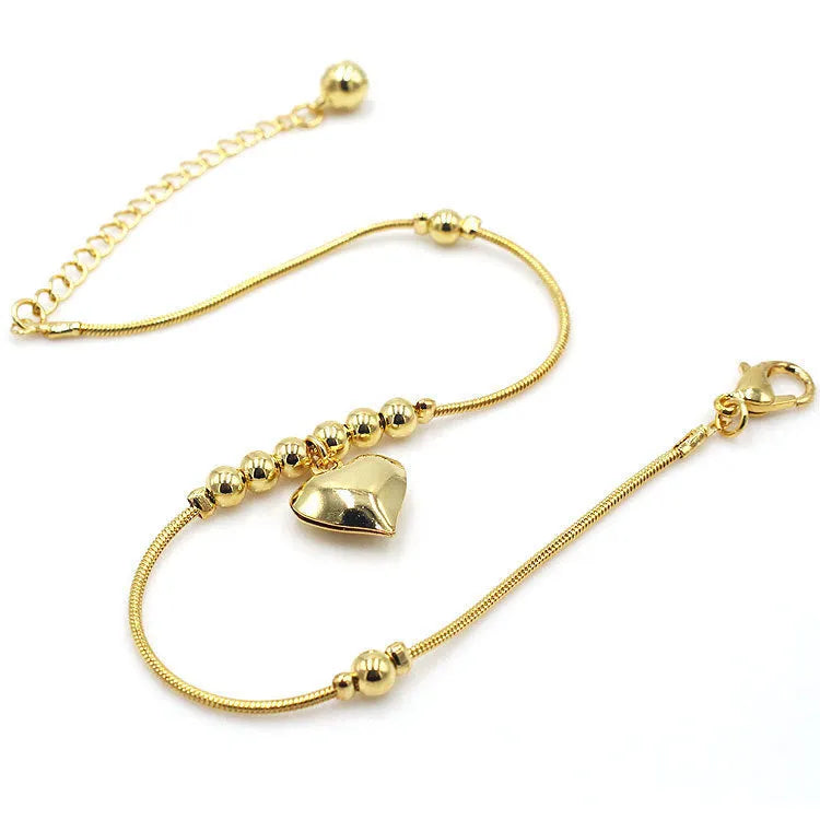 Gold colour gothic heart pendant anklet on a woman's ankle with chunky ball beads and copper chain 27cm