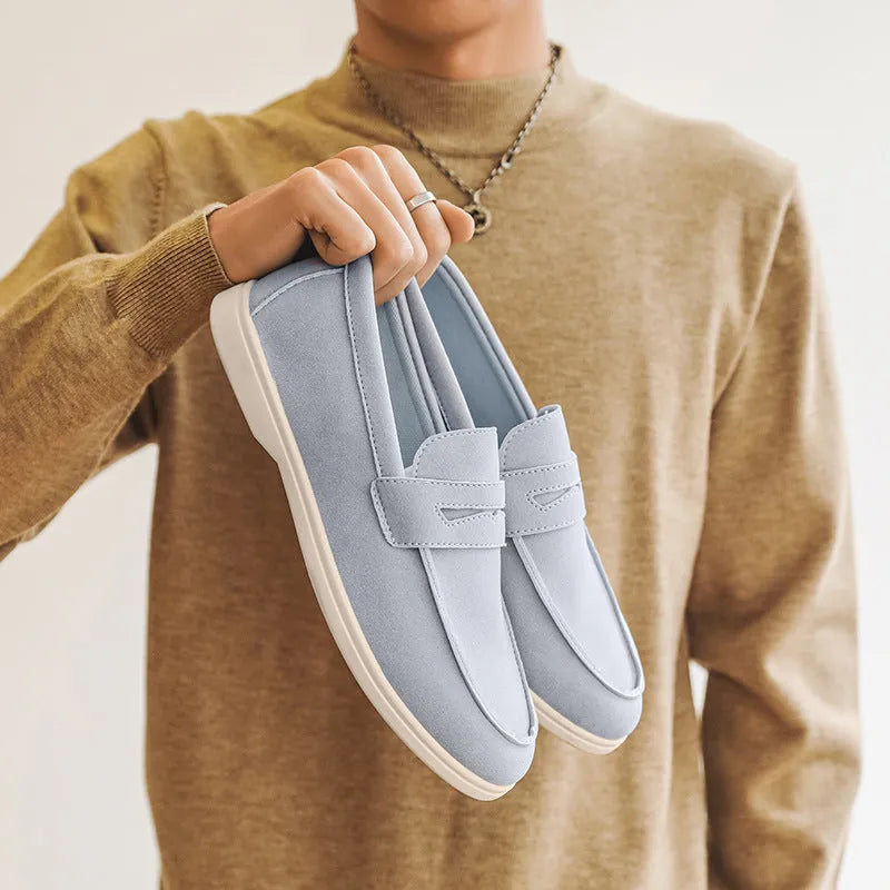 Men's beige suede British style casual slip-on shoes with a round toe and low flat heel on a rubber sole.