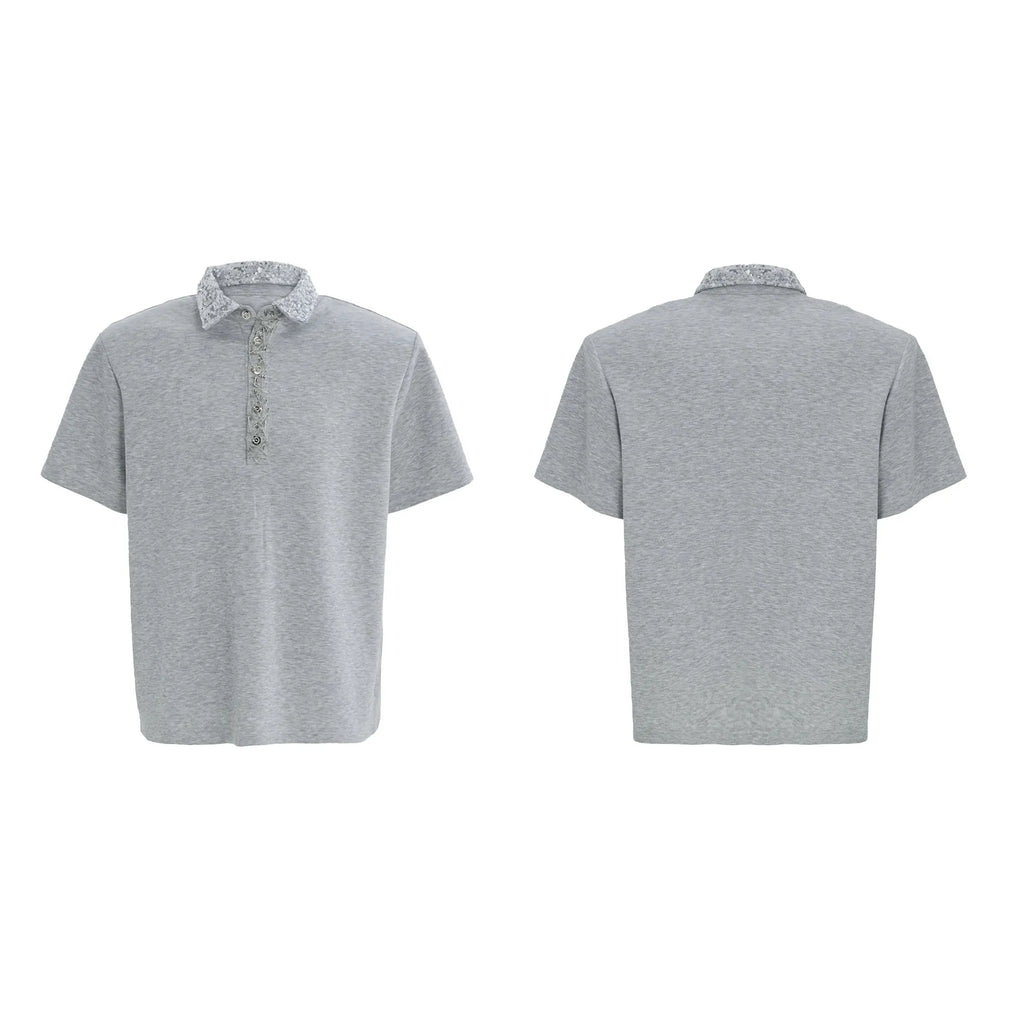 Man wearing a loose fit black polo shirt with a square collar and short sleeves.