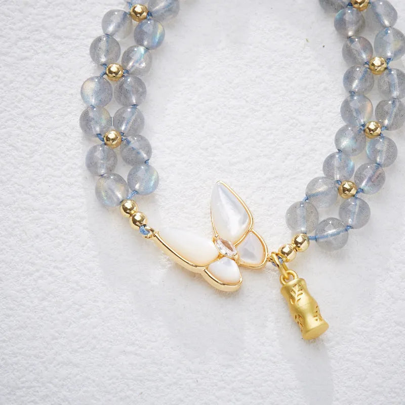 Grey moonstone woven bracelet with butterfly pattern and silver tone clasp