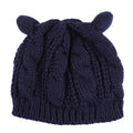 Handmade red knitted beanie with 3D cat ears and a pom pom on a mannequin head