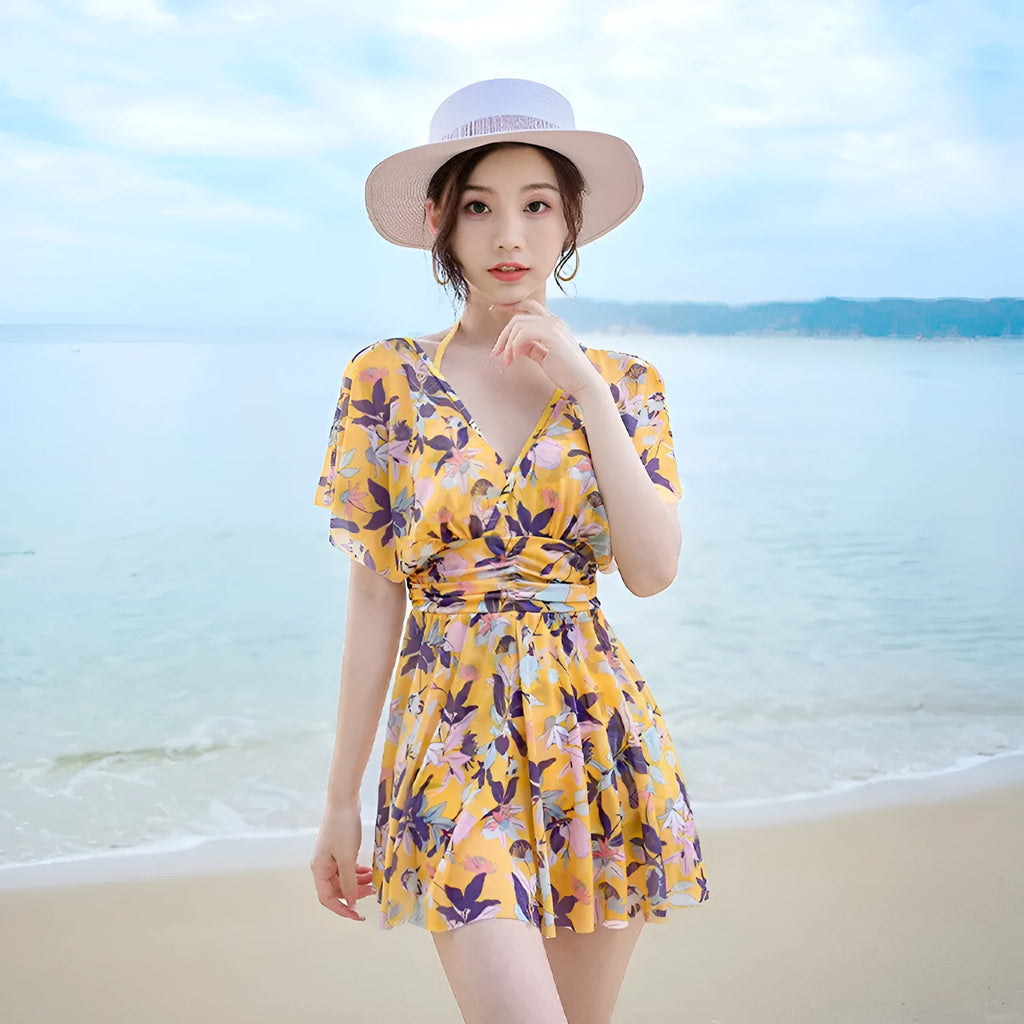 Yellow floral print women's one-piece swimsuit with skirted design.