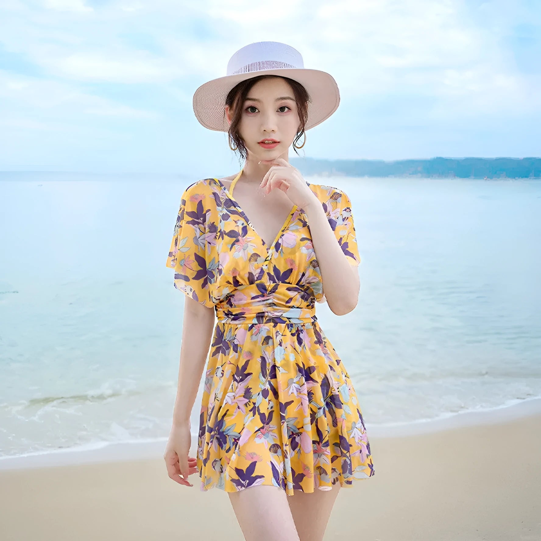 Yellow floral print women's one-piece swimsuit with skirted design.