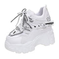 White women's low-top mesh platform sports shoe with a cross strap and rubber sole.