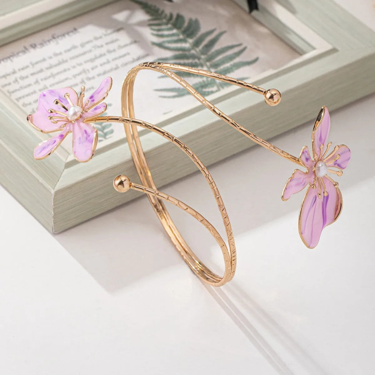 Pink hollow-out pattern alloy armband with adjustable lines on a wrist.