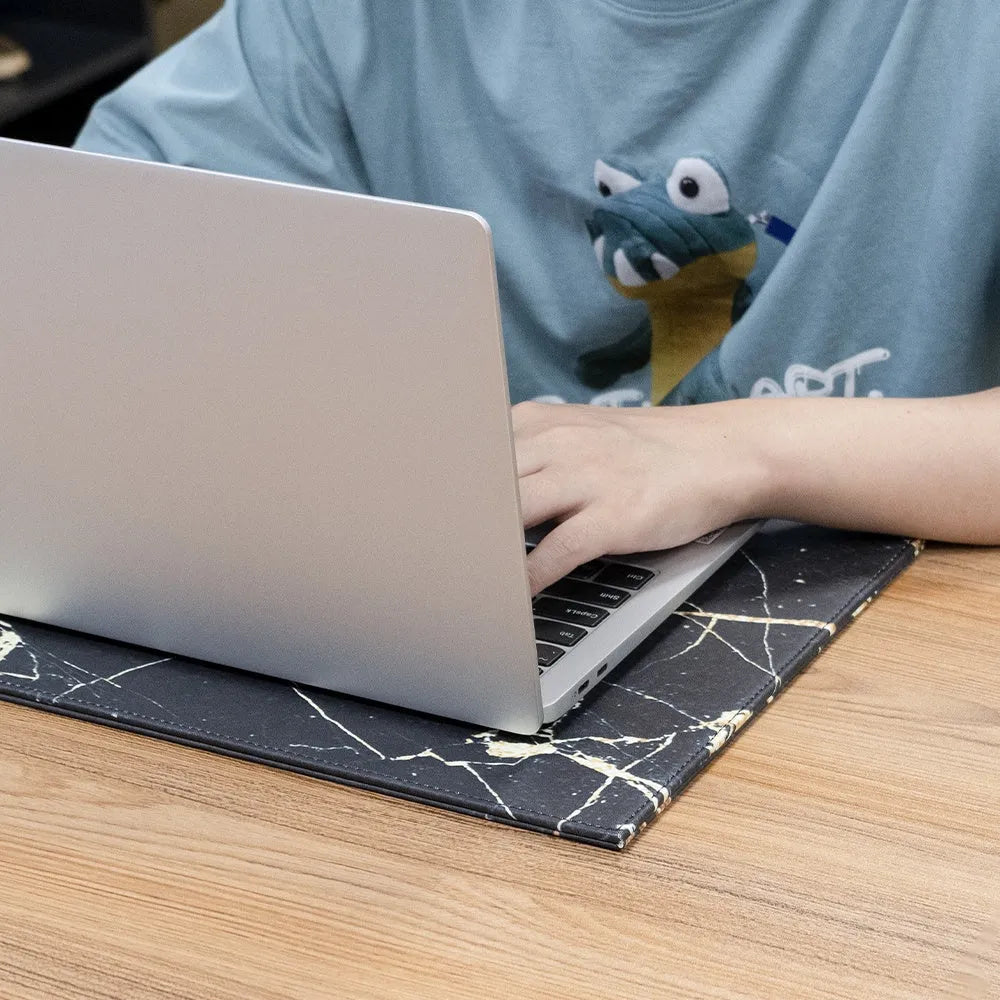 Durable heat-insulating anti-radiation laptop pad in black, black gold, blue, and green colour options on a desk.