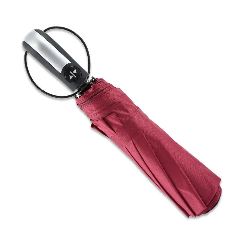 Triple-folding automatic black business umbrella with steel ribs and rubber handle, shown open.