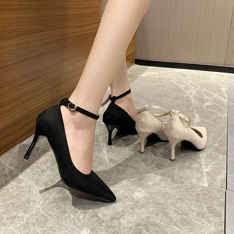 Women's black stiletto pumps with skull pattern and buckle detail on rubber sole