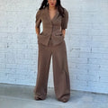 Brown men's slim fit polyester suit with long sleeve top and full length trousers on a hanger