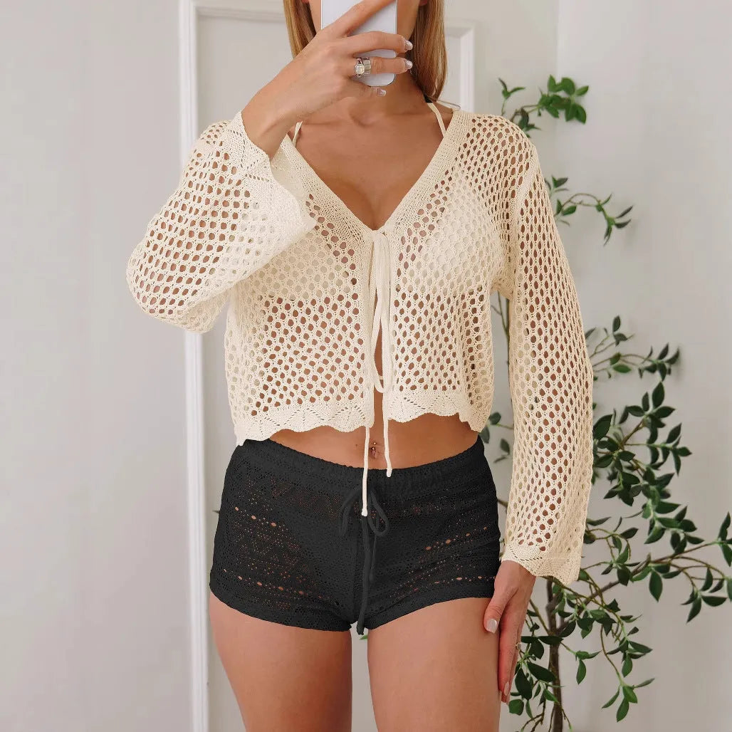 Short apricot coloured women's cardigan blouse with flared bell sleeves, laid flat.