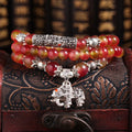Handmade natural watermelon crystal bracelet with a Chinese knot, showing geometric beads in elephant style.