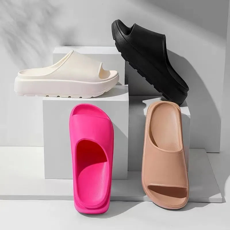 Women's beige fish mouth slippers with a thick light-coloured sole on a wooden floor.