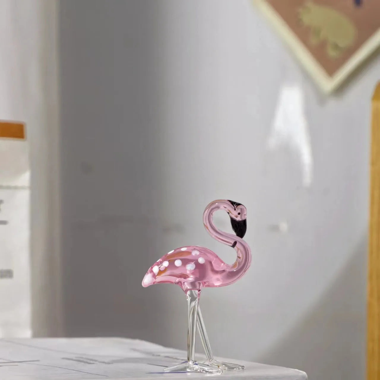 Pink flamingo crystal decorative ornament on a table in modern minimalist style.