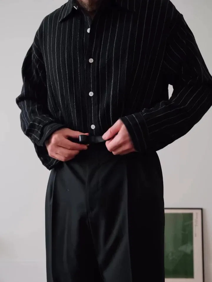 Men's black pinstriped button-down long sleeve shirt made from polyester fabric.