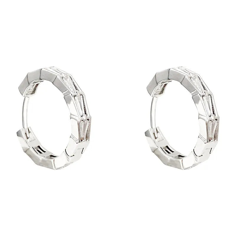 Silver-toned copper geometric eardrop earring with small zircon accent on white background