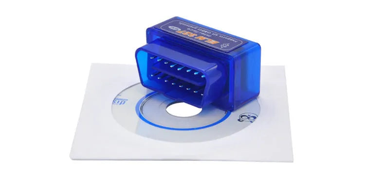 Small black OBD2 Bluetooth scanner car diagnostic code reader next to a vehicle's diagnostic port.