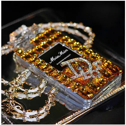 Perfume bottle bow design iPhone case with textured TPU silicone and a fixed metal chain, shown in black, gold, pink, and transparent.