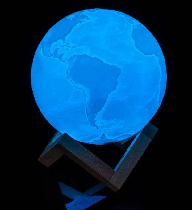 3D printed white moon lamp with detailed lunar surface texture on a wooden holder.