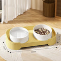 Green ceramic elevated cat feeder with two tilted bowls on a non-slip stand