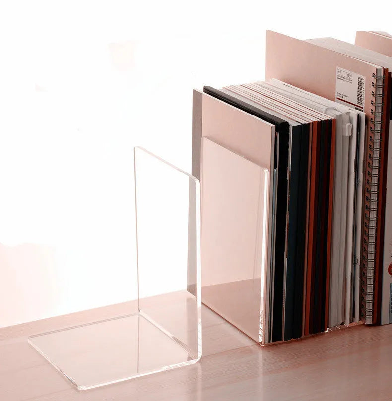 Transparent acrylic bookshelf displaying books in organised pairs on a desk