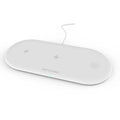 Black and white three-in-one wireless charging station for Apple iPhone, iWatch, and headphones on a desk.