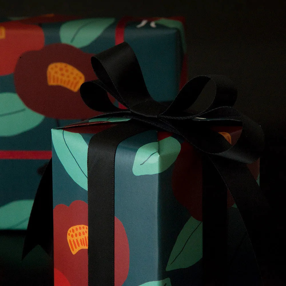Green waterproof Christmas gift wrapping paper with Camellia floral pattern and ribbon accent