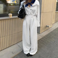 White striped wide-leg women's trousers with a front zip on a hanger.