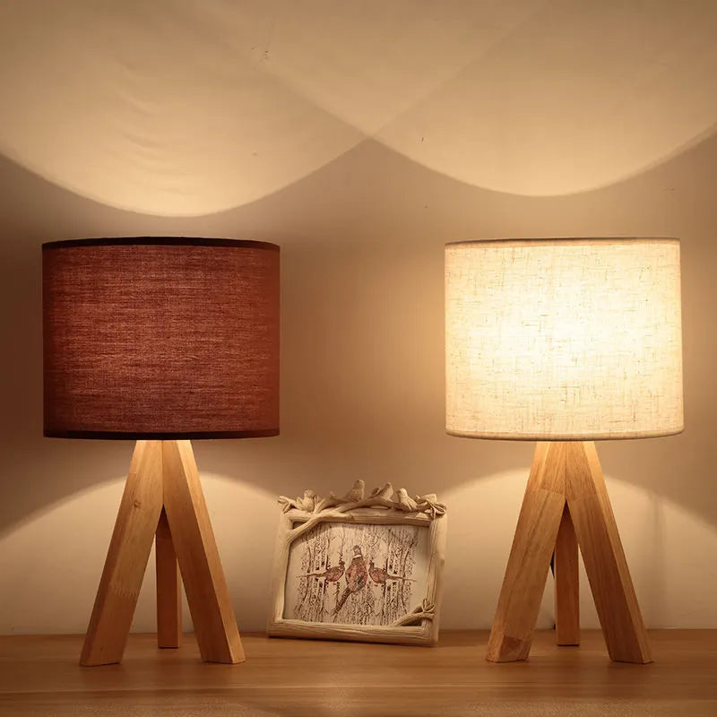 Solid wood LED table lamp with fabric shade in linen trumpet colour on wooden bedside table