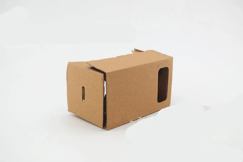 Pink and white cardboard VR glasses with 3D lenses and a rubber head strap for smartphones.