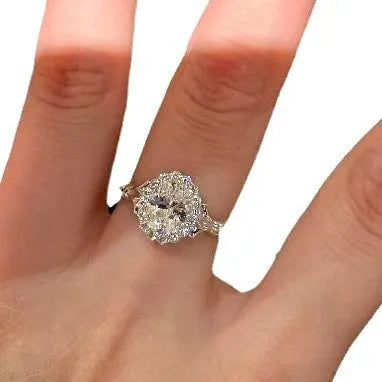 Silver geometric elliptical ring with large diamond on model's index finger, showcasing adjustable opening.