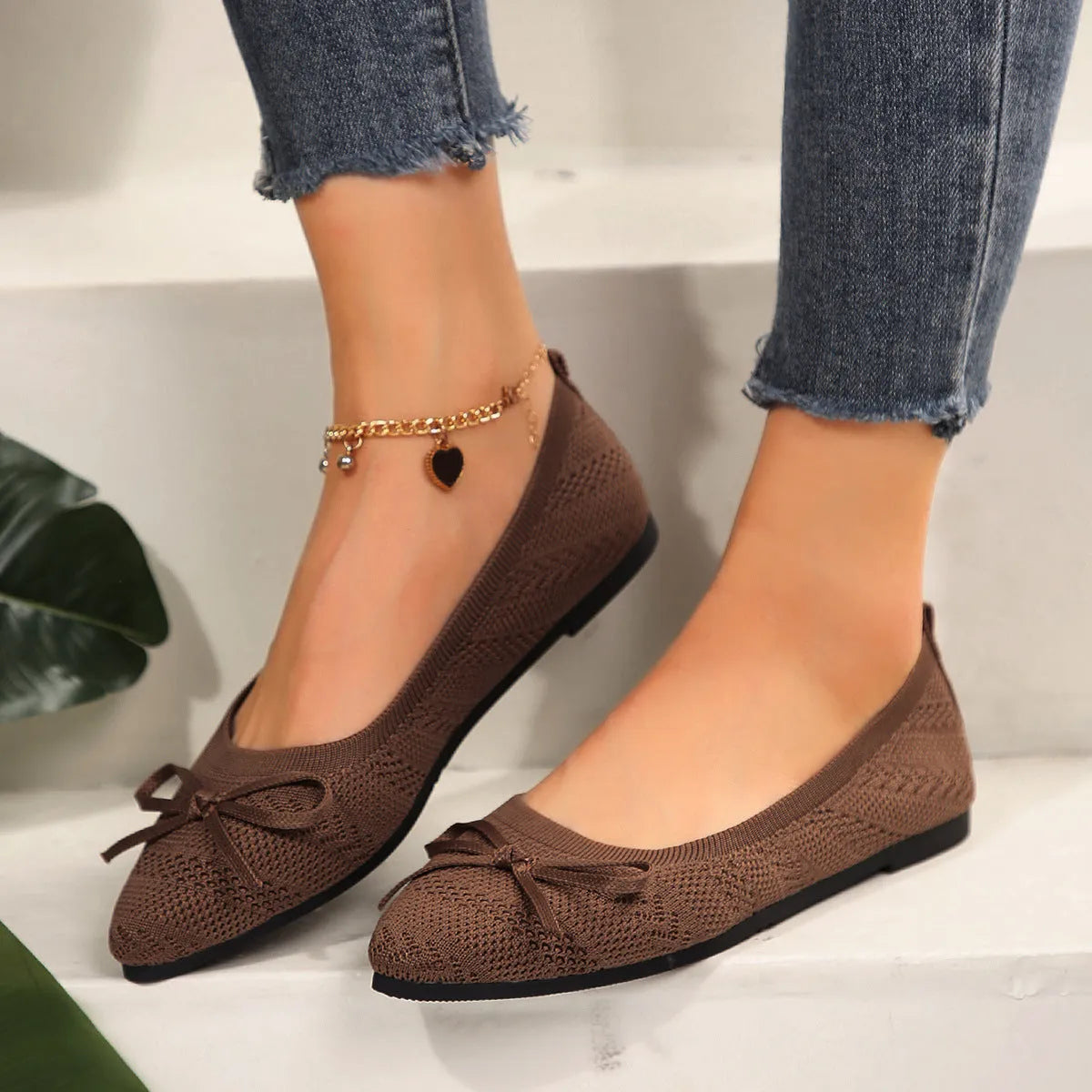 Women's knitted flat loafers with a bow and pointed toe in blue, shown from the side.