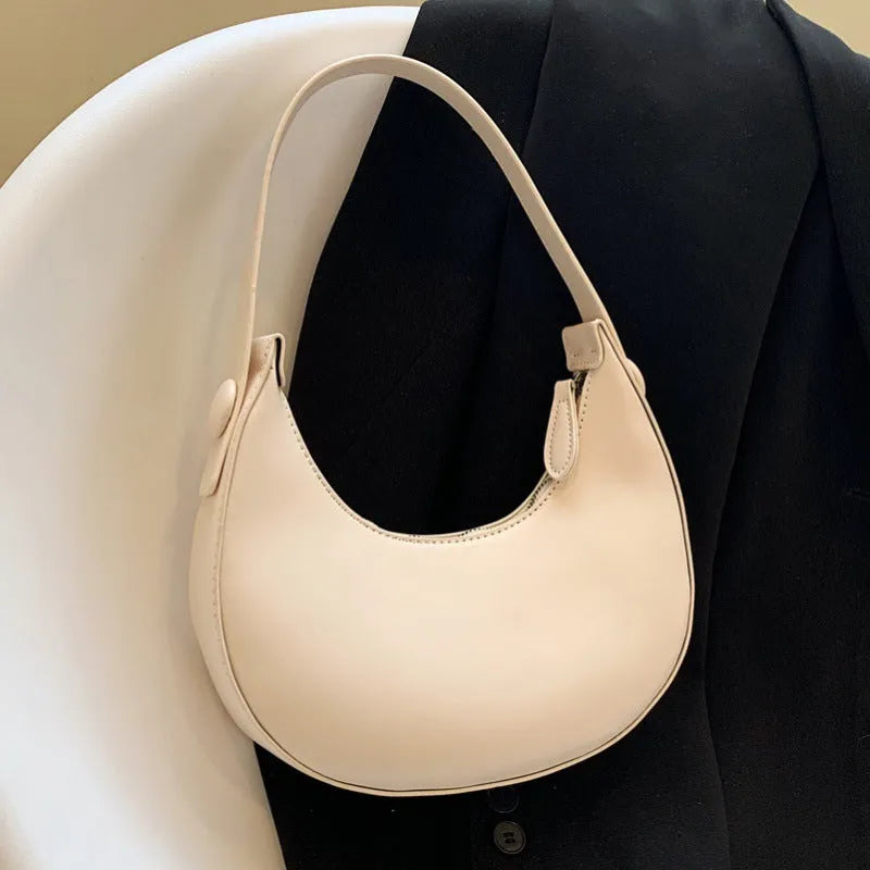 Women's retro dumpling-shaped PU shoulder bag in cream yellow with a zippered compartment.