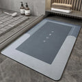 Machine woven bathroom floor mat in blue colour, shown in an oval shape on a tiled floor.