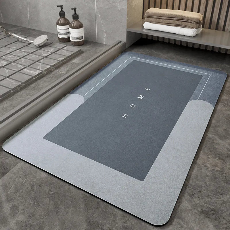 Machine woven bathroom floor mat in blue colour, shown in an oval shape on a tiled floor.