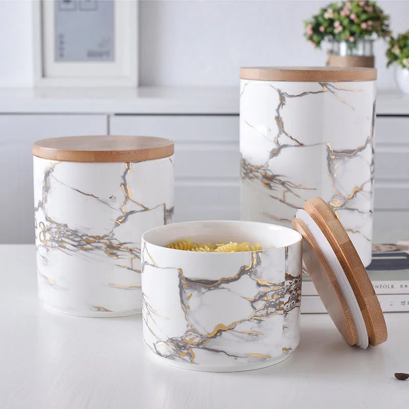 3 piece marbled ceramic jar set with wooden lids large medium and small on a countertop