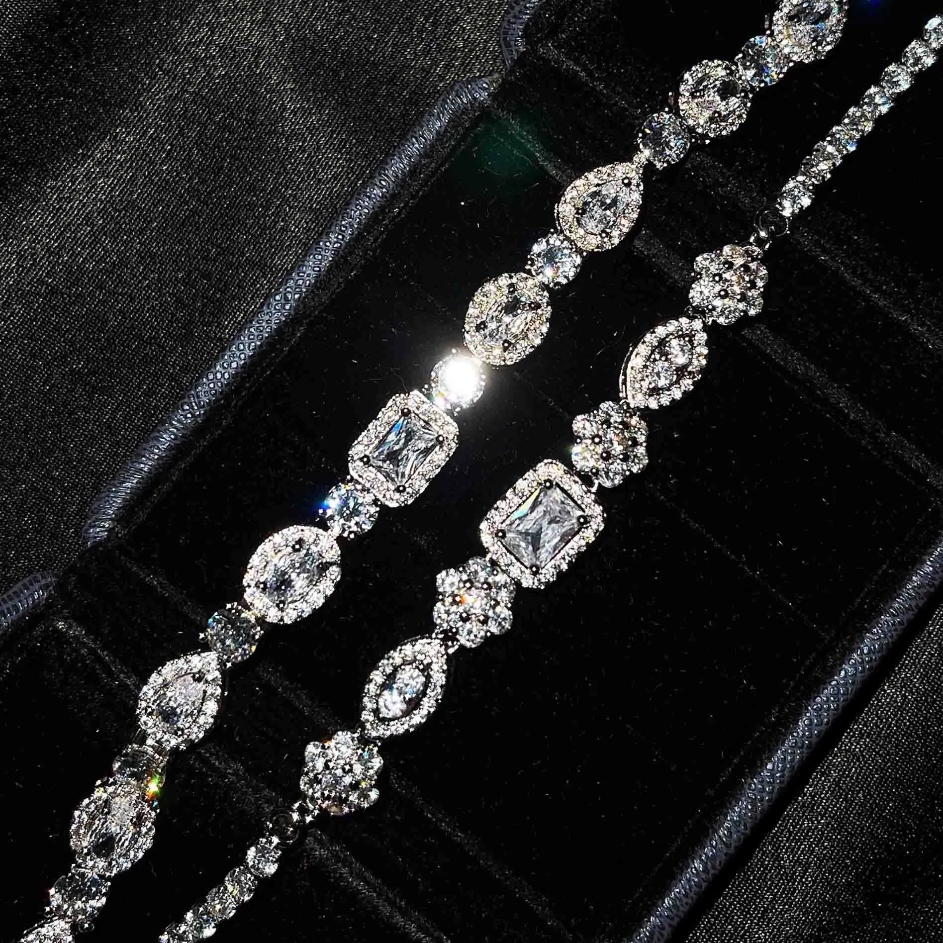 Close-up of a women's geometric silver bracelet with sparkling inlaid zircon stones and a lobster clasp.