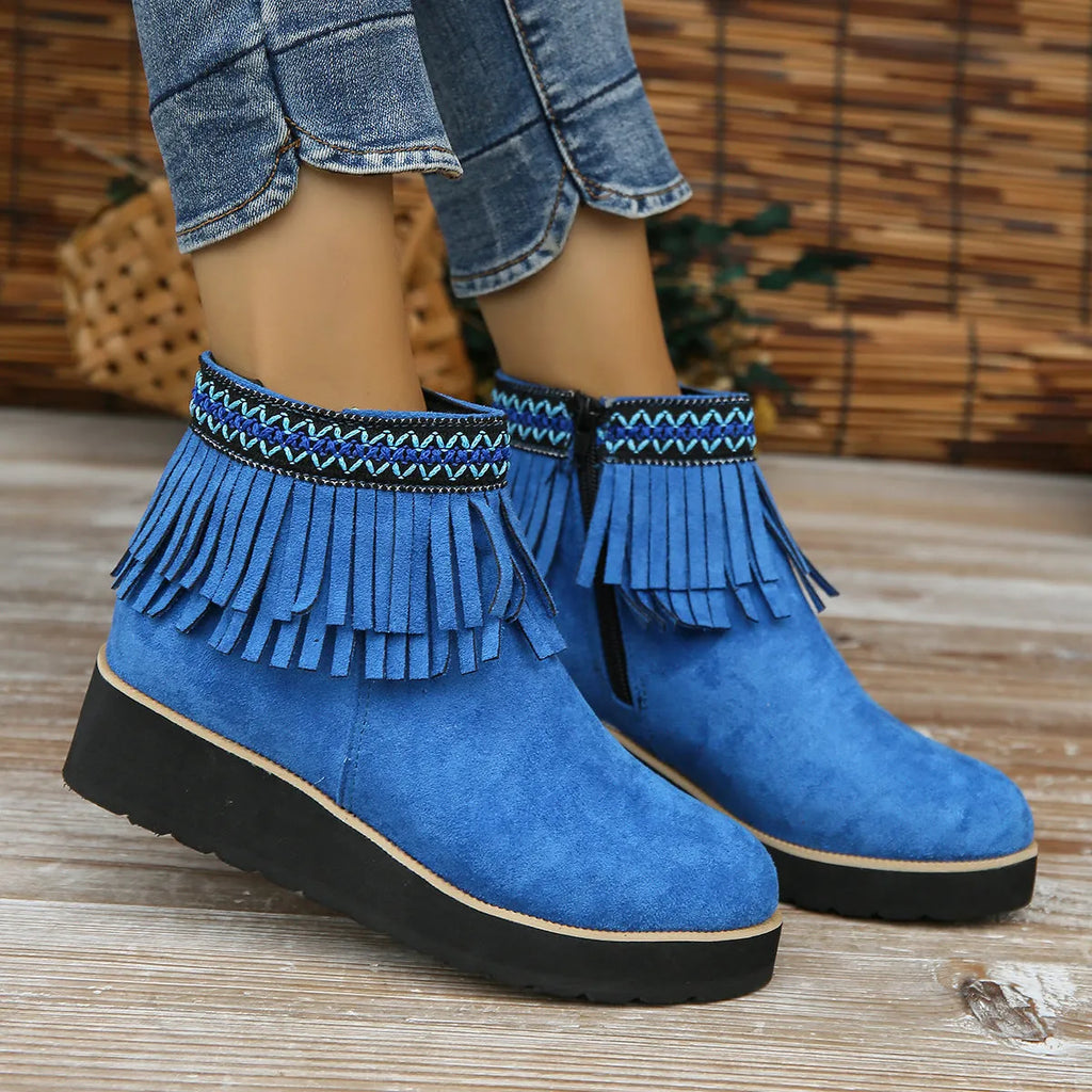 Women's dark brown suede ankle boots with a wedge heel, thick platform sole, tassel detail, and side zipper.