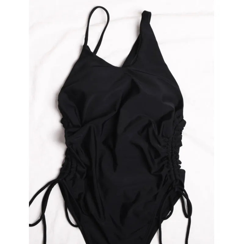 Black sleeveless women's dress with sloping shoulders and adjustable lacing detail