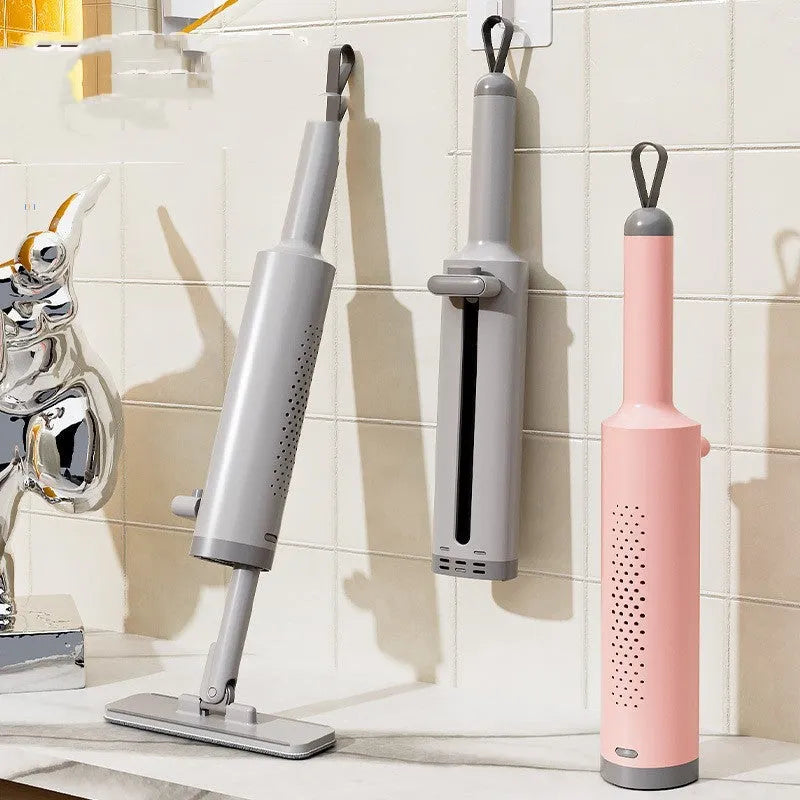 Pink self-squeezing rotatable mini flat mop with microfiber pad on a hardwood floor.