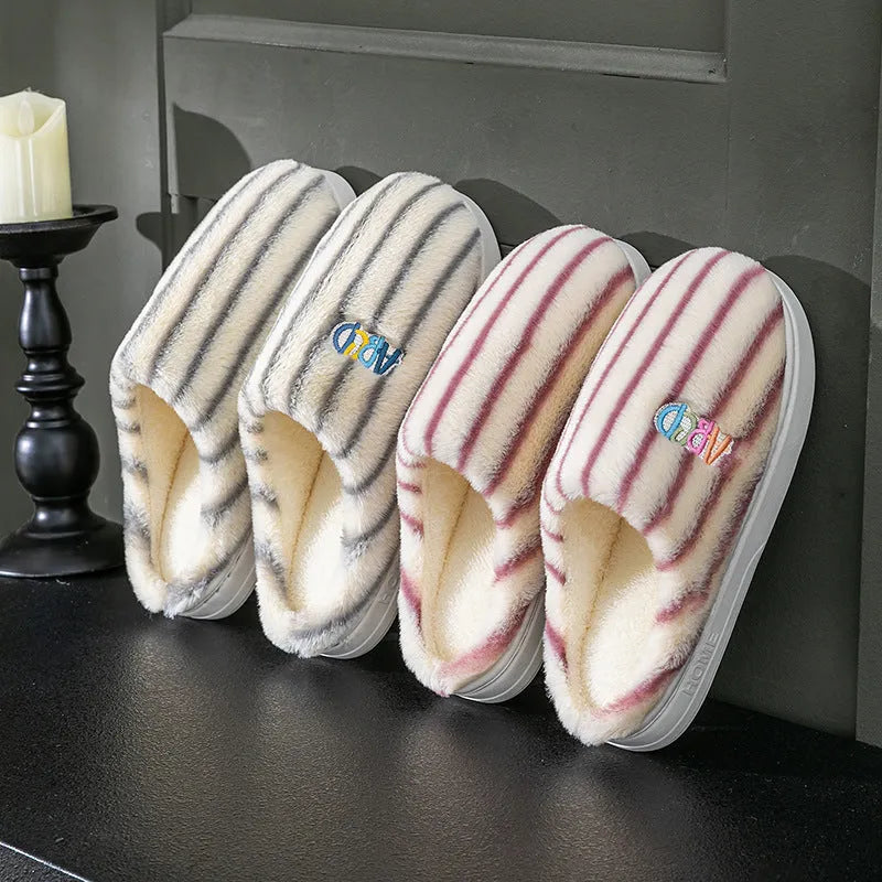 A pair of soft cotton adult slippers with a plastic sole, shown in one of five colour options.