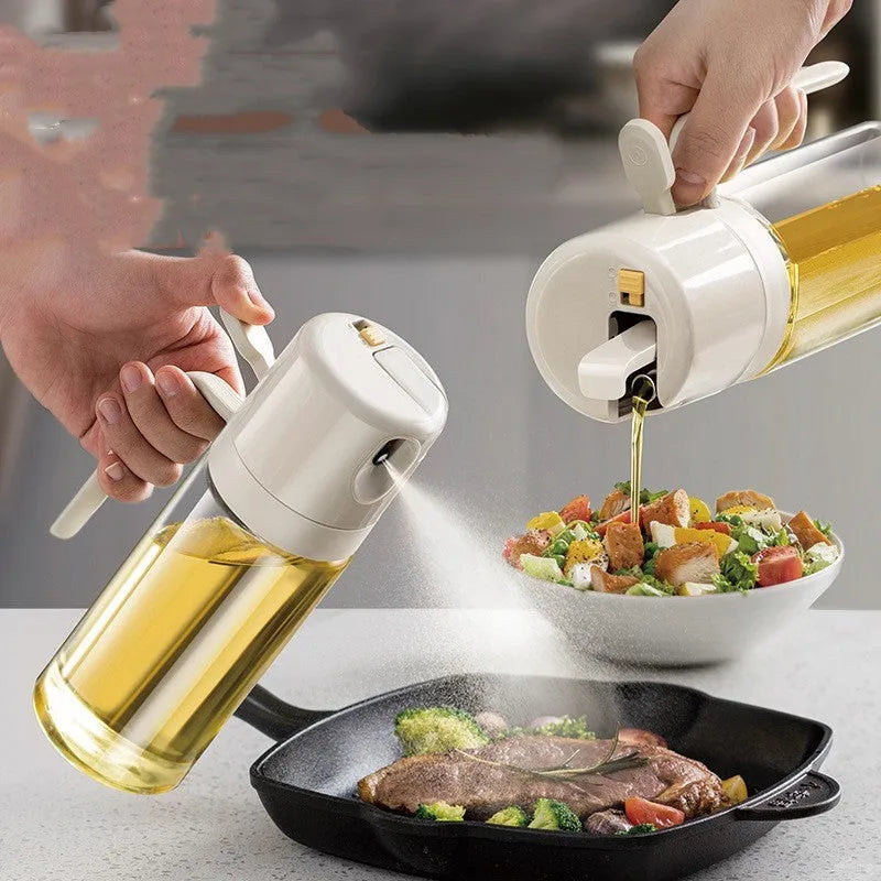 Warm grey glass oil sprayer bottle with a dual-mode cap switch, shown on a kitchen counter.