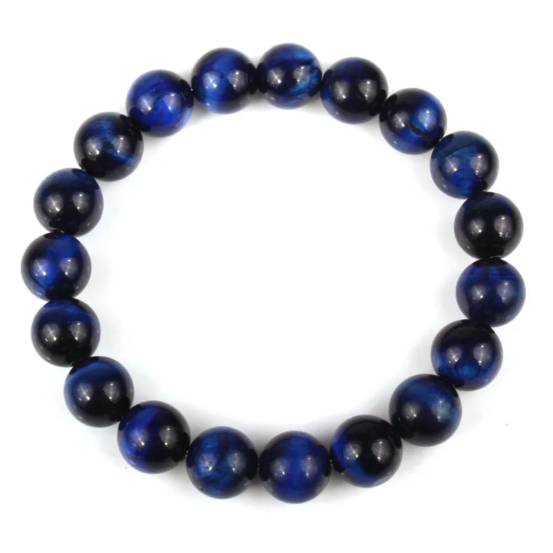 Natural tiger's eye crystal bracelet with round geometric beads in various colours and sizes on a wrist.