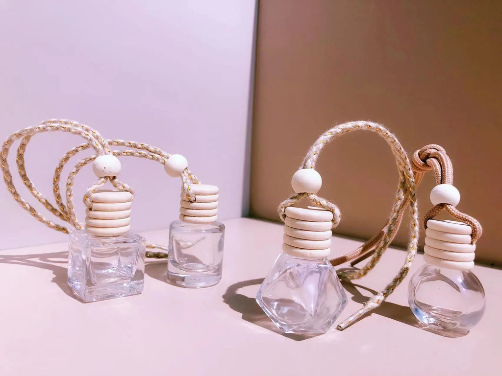 Car air vent perfume pendant showing cylinder, diamond, flat drum, and square glass bottle designs
