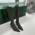 Women's black pointed toe stiletto boots with a back zipper, shown from the side.