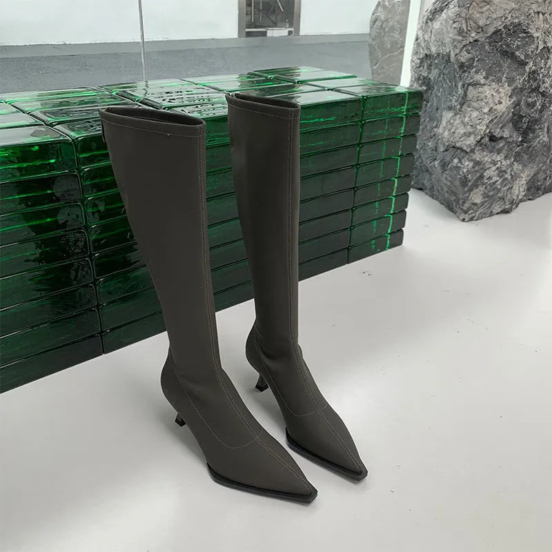 Women's black pointed toe stiletto boots with a back zipper, shown from the side.