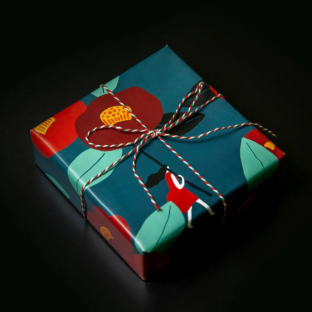 Green waterproof Christmas gift wrapping paper with Camellia floral pattern and ribbon accent