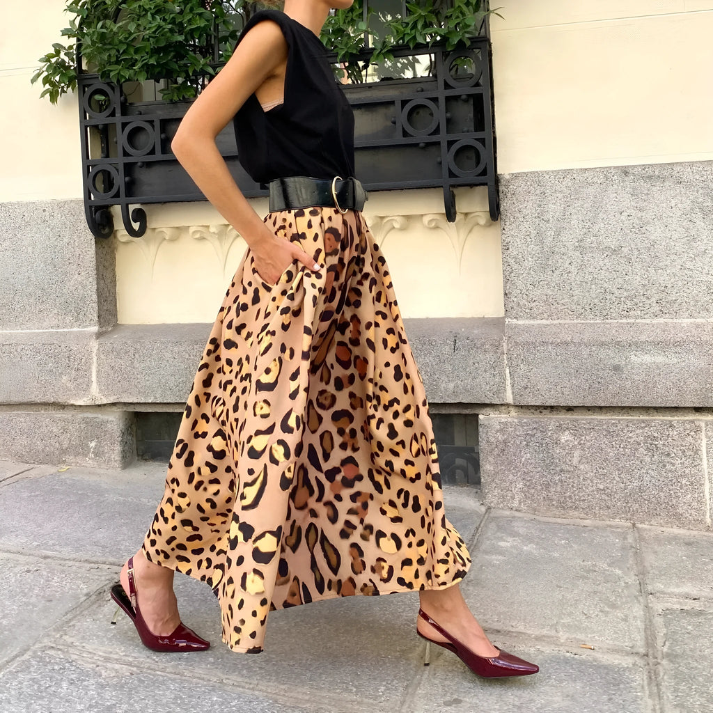 Brown leopard print women's long A-line skirt with a wide flowing hem, shown on a hanger.