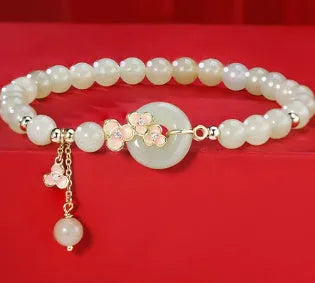 Peach blossom Hetian jade bracelet and necklace set with flower-shaped beads in sterling silver setting